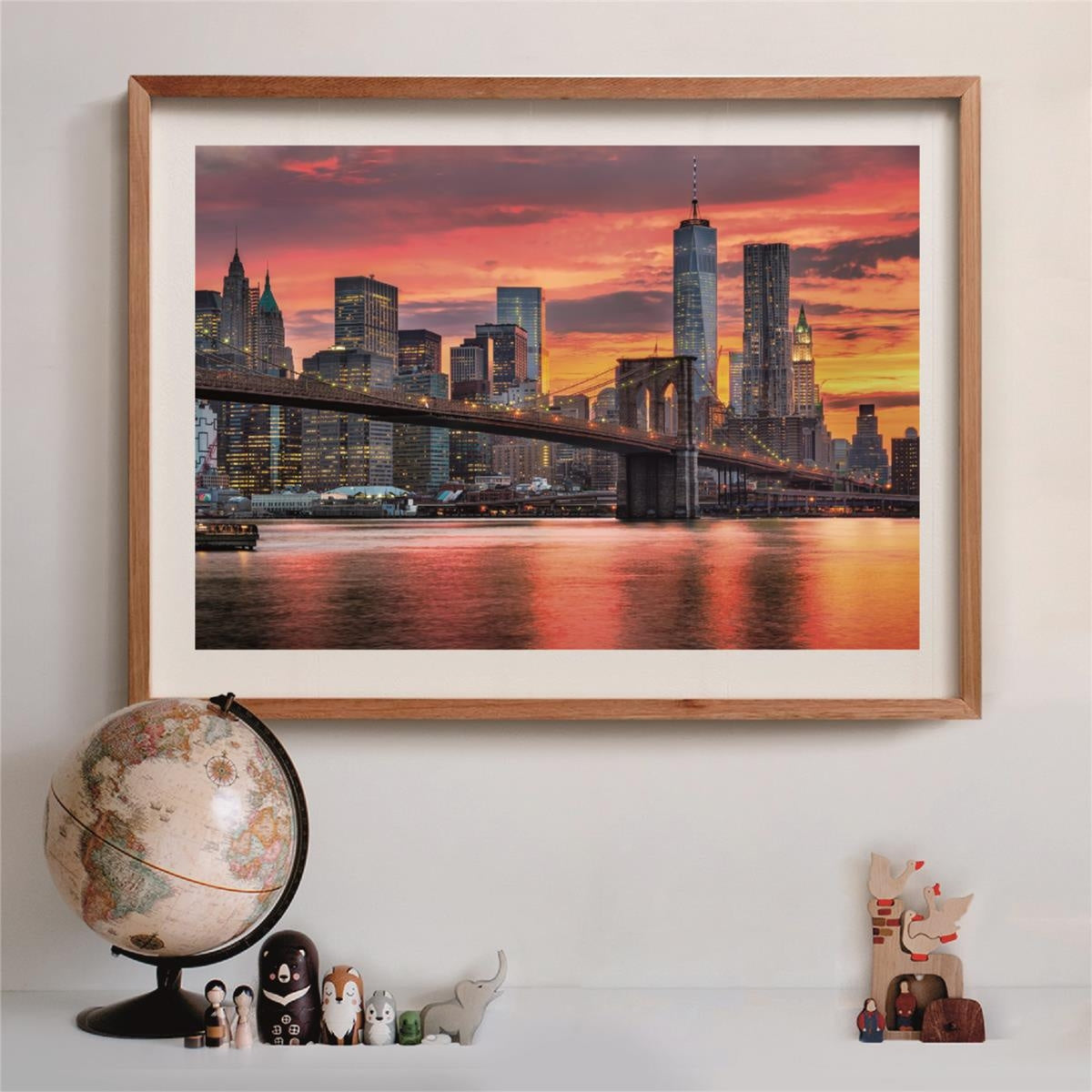 Framed photo: Brooklyn Bridge and Manhattan skyline glow at sunset, reflected in vivid water