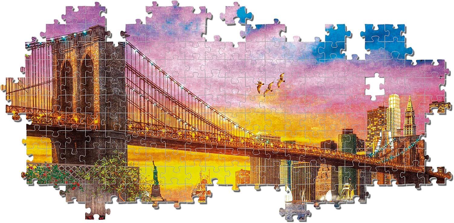 An unfinished jigsaw puzzle depicting the Brooklyn Bridge and NYC skyline at dusk, with a vibrant pink and orange sky