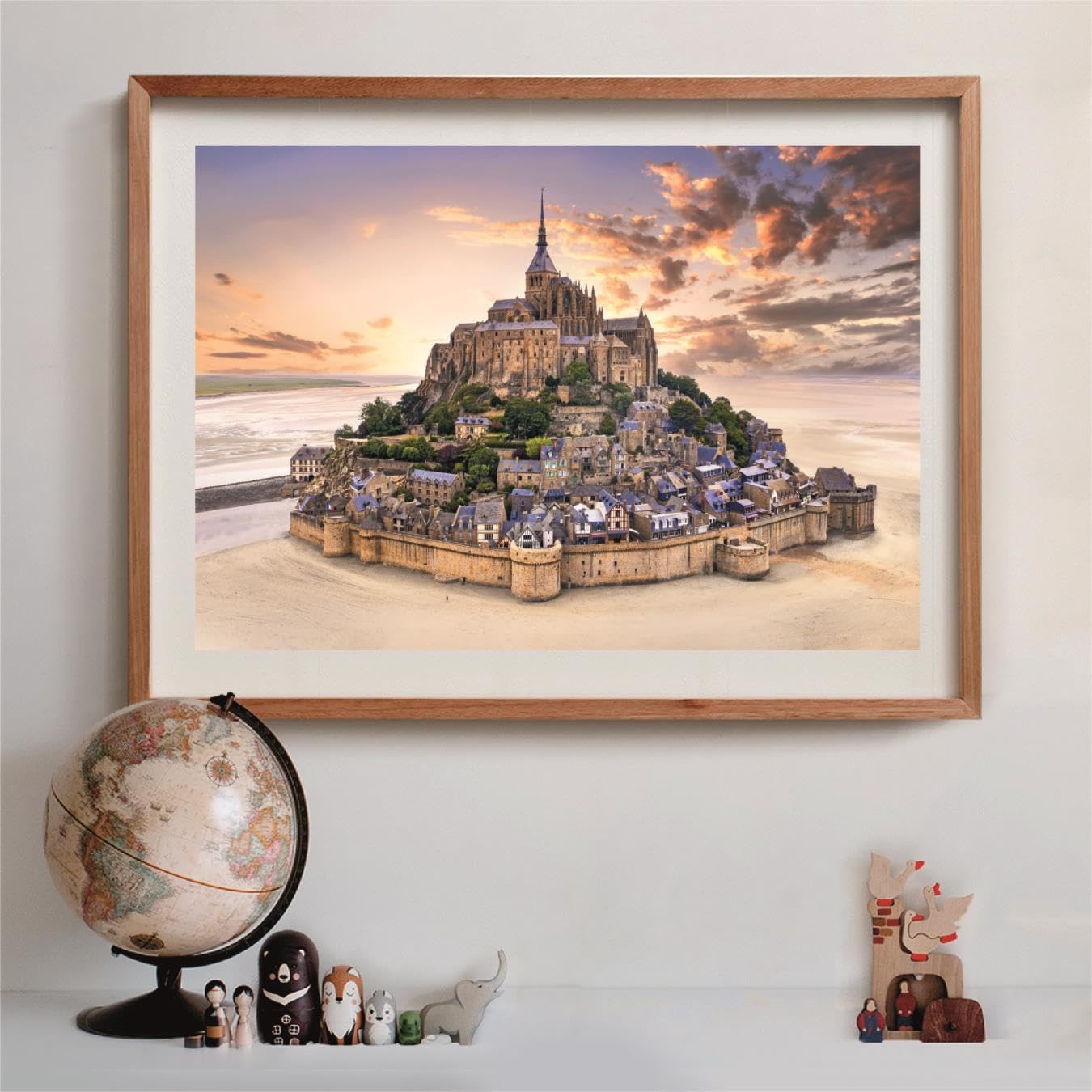 Framed puzzle of Mont Saint-Michel, a fortified abbey and town on a tidal island, under a dramatic sunset sky