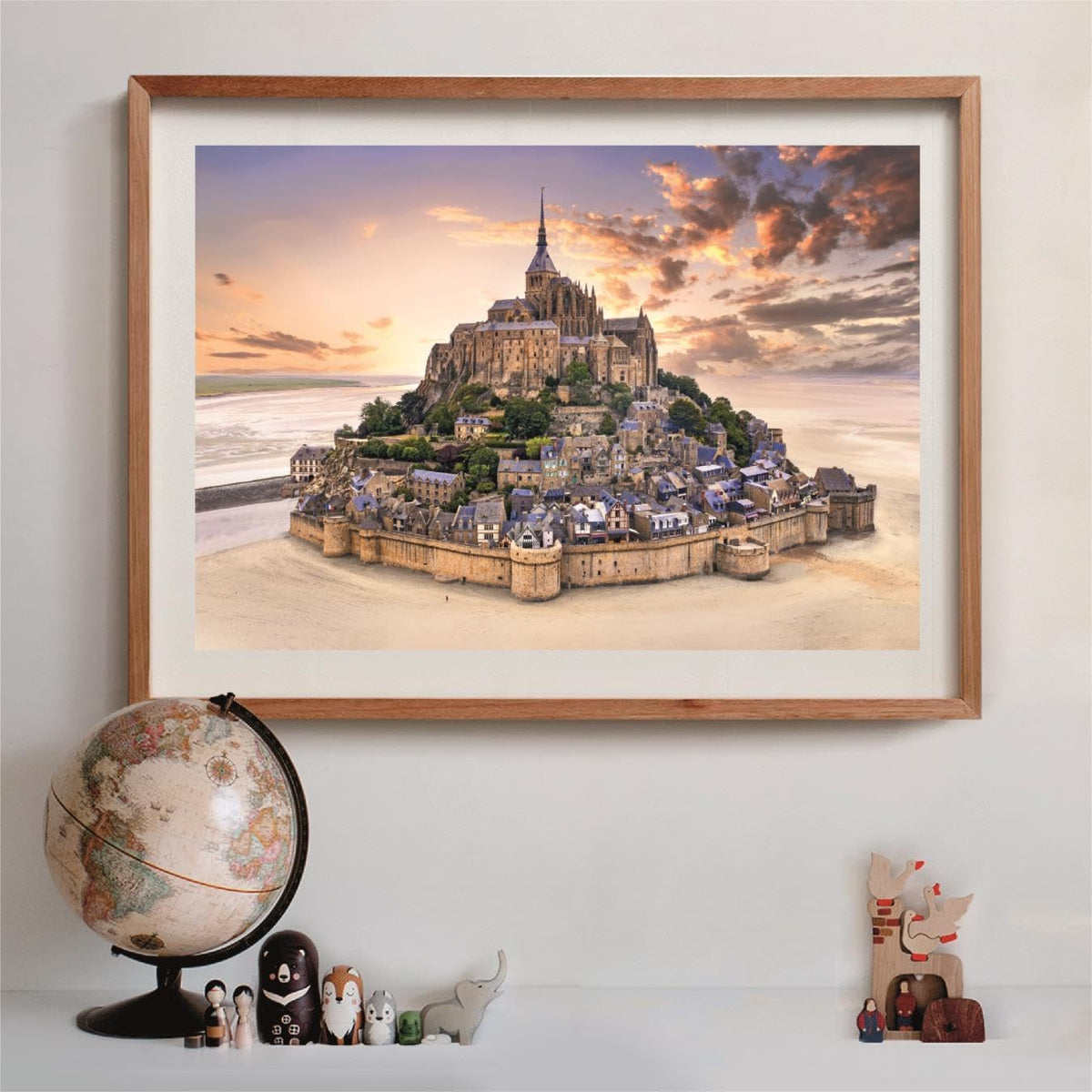 Framed puzzle of Mont Saint-Michel, a fortified abbey and town on a tidal island, under a dramatic sunset sky