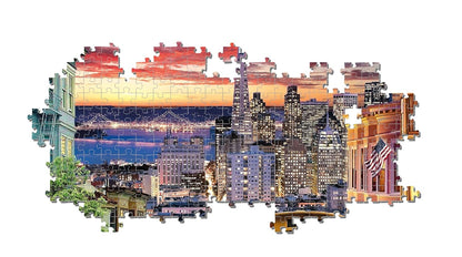A jigsaw puzzle shows San Francisco at sunset, with the Bay Bridge, illuminated buildings, and an American flag