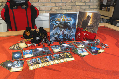 Cult of the Deep board game box and components laid out on a red mat: cards, dice, tokens, and bags