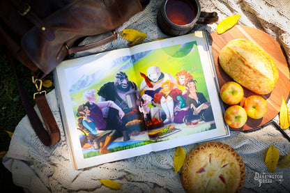 An open book on a blanket displays a colourful fantasy illustration of 8 characters picnicking, surrounded by bread, apples, and a pie