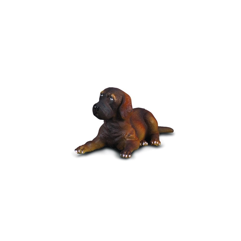 Brown puppy figurine lying down, looking left