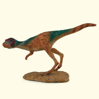 A reddish-brown and green bipedal dinosaur model in a running stance on a textured base