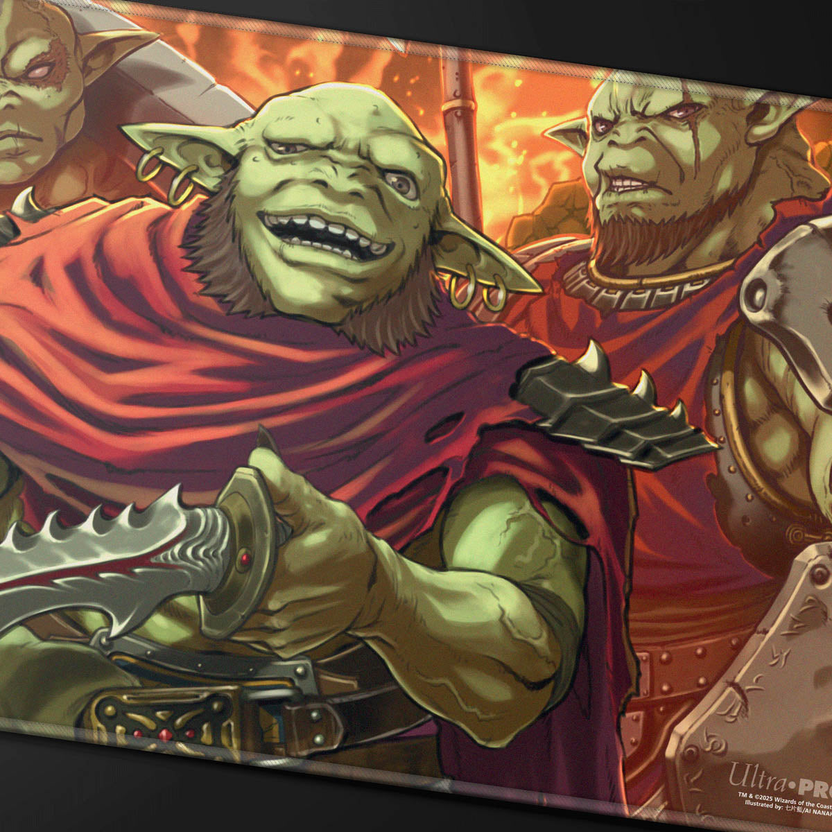 Playmat: A smiling green goblin in a red cloak holds a serrated dagger, flanked by two other goblins against a fiery background