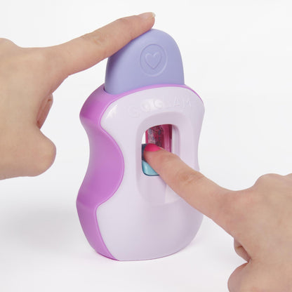 Hands operating a purple and white GoGlam nail stamper, pressing a pink-painted fingernail inside to apply patterns