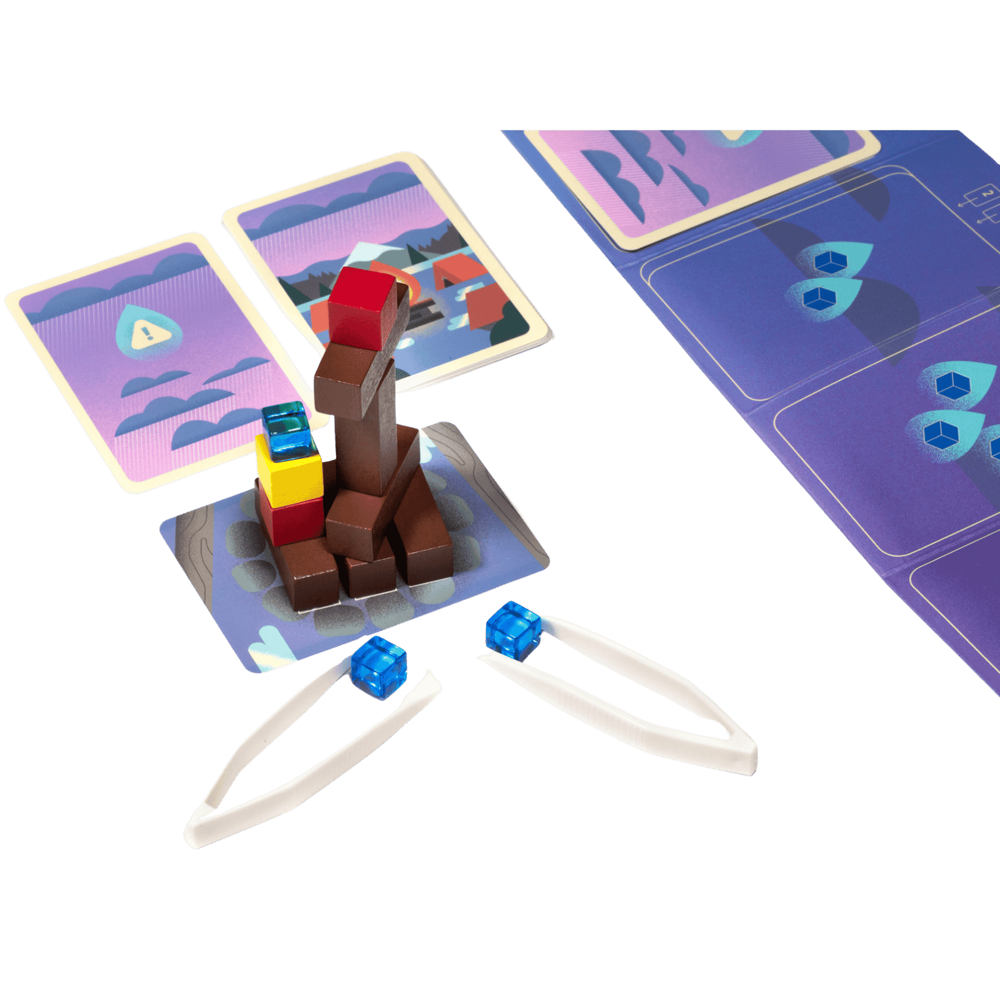 Tweezers holding blue cubes near a stacked tower of colorful wooden blocks and game cards