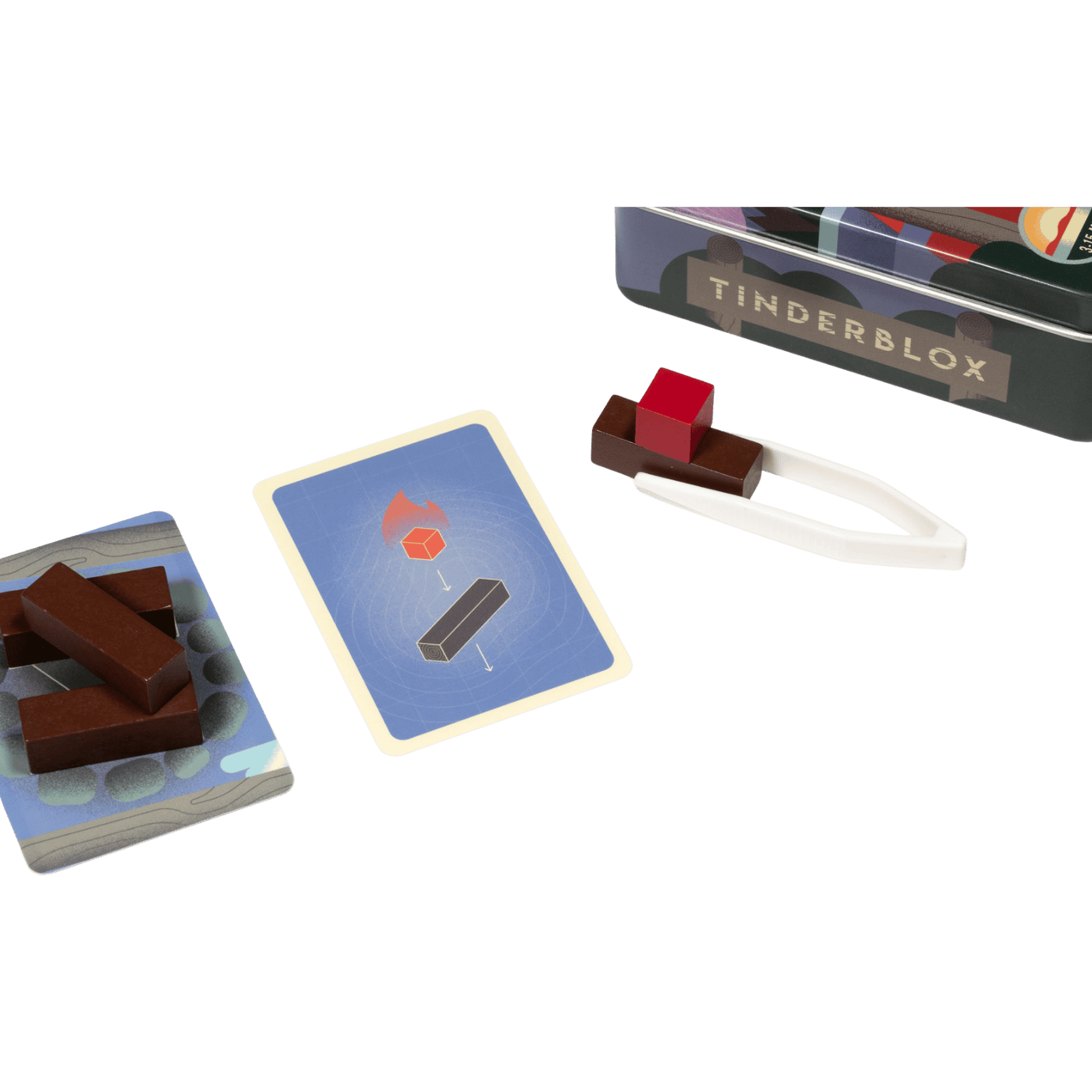 Tinderblox game set: wood blocks, challenge cards, white tongs holding a red block, and the game tin