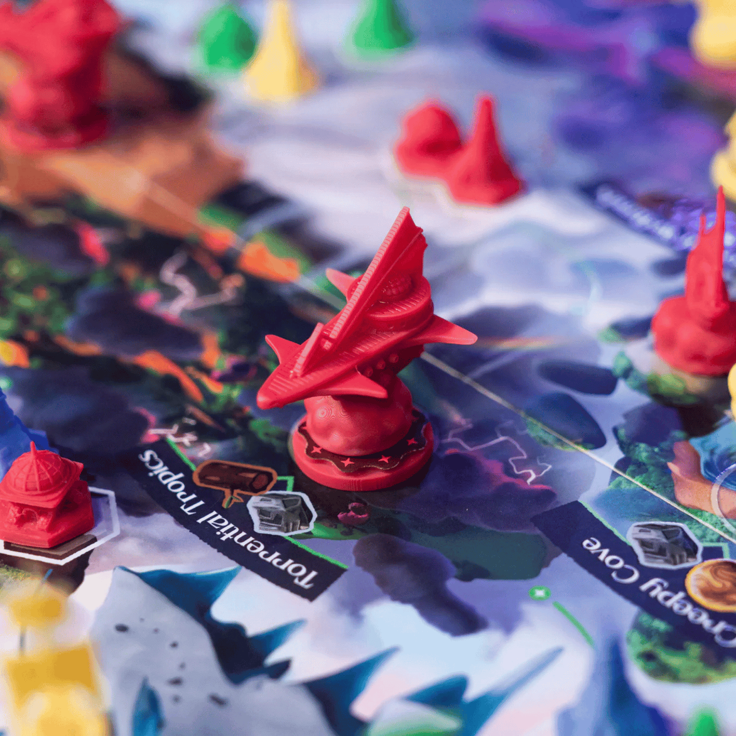 Detailed red plastic spaceship miniature token on a vibrant board game map with other conical pieces