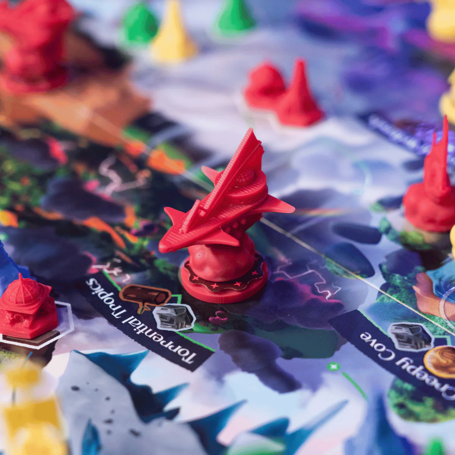 Detailed red plastic spaceship miniature token on a vibrant board game map with other conical pieces
