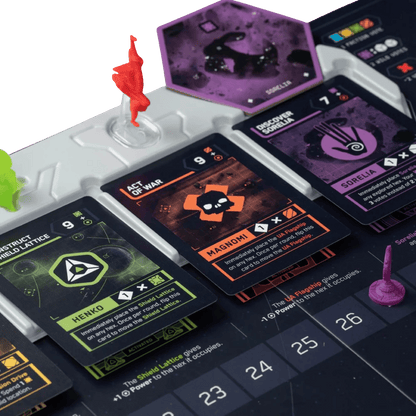 Close-up of a science fiction board game setup showing cards (Henko, Magnomi, Sorelia) and plastic miniatures