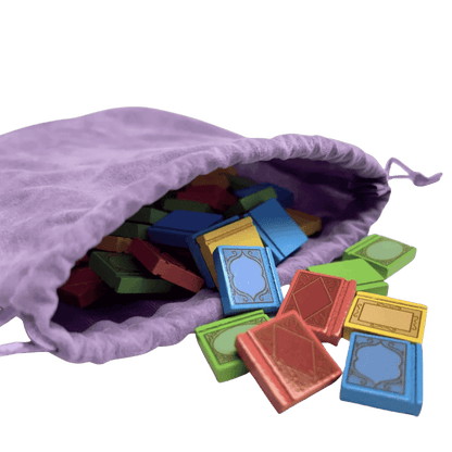 Miniature, colorful book-shaped game tokens spilling out of a purple bag