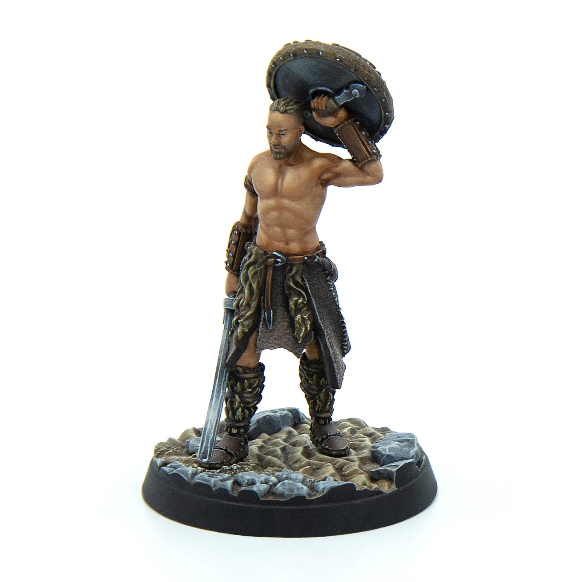 Painted miniature of a muscular, shirtless warrior holding a round shield overhead and a long sword