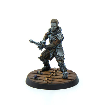 Painted miniature of a grey-skinned warrior with red eyes in ornate armor, wielding a crossbow on a wooden base