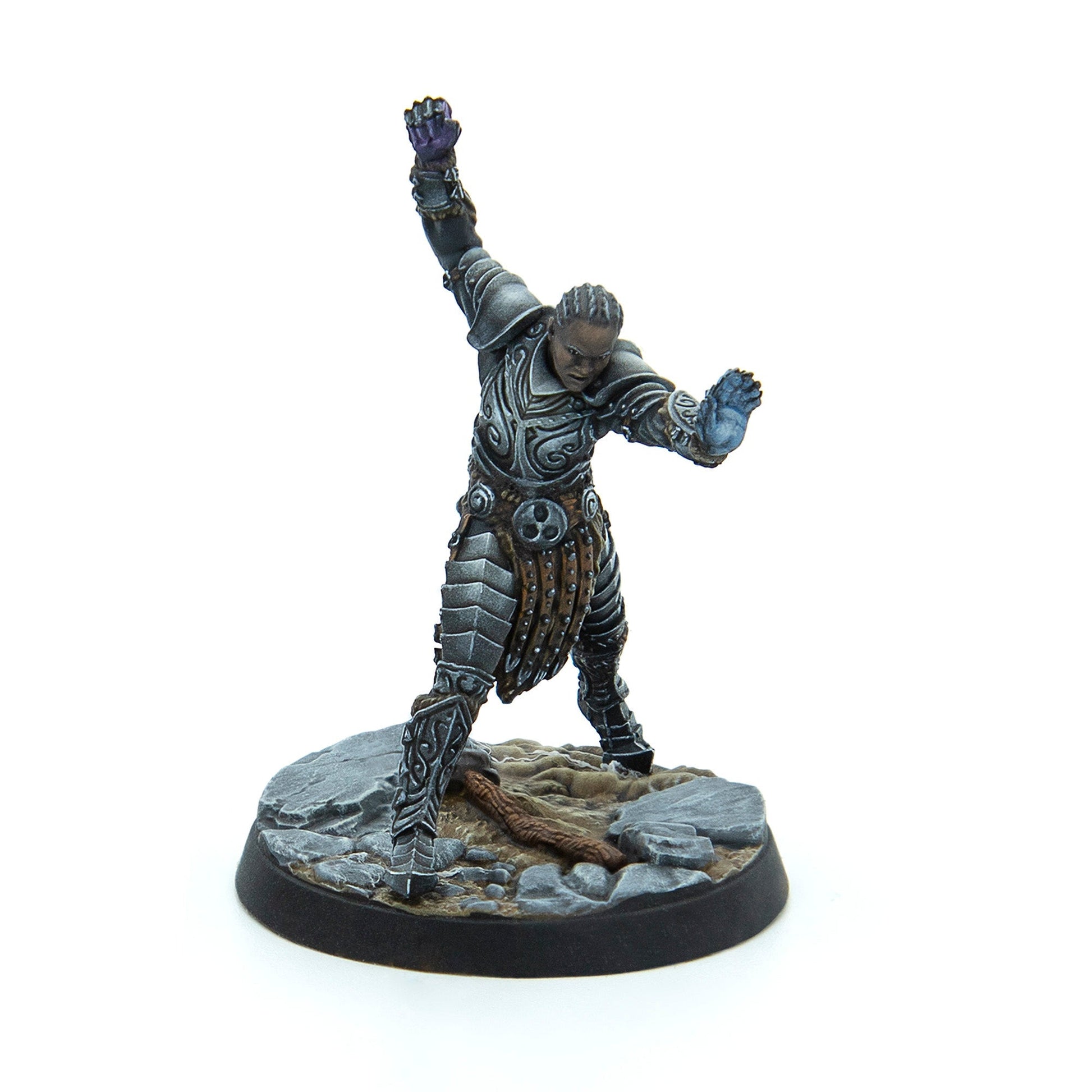 A dark-skinned warrior miniature in grey armor, casting a spell with one purple-glowing fist and one blue-glowing hand