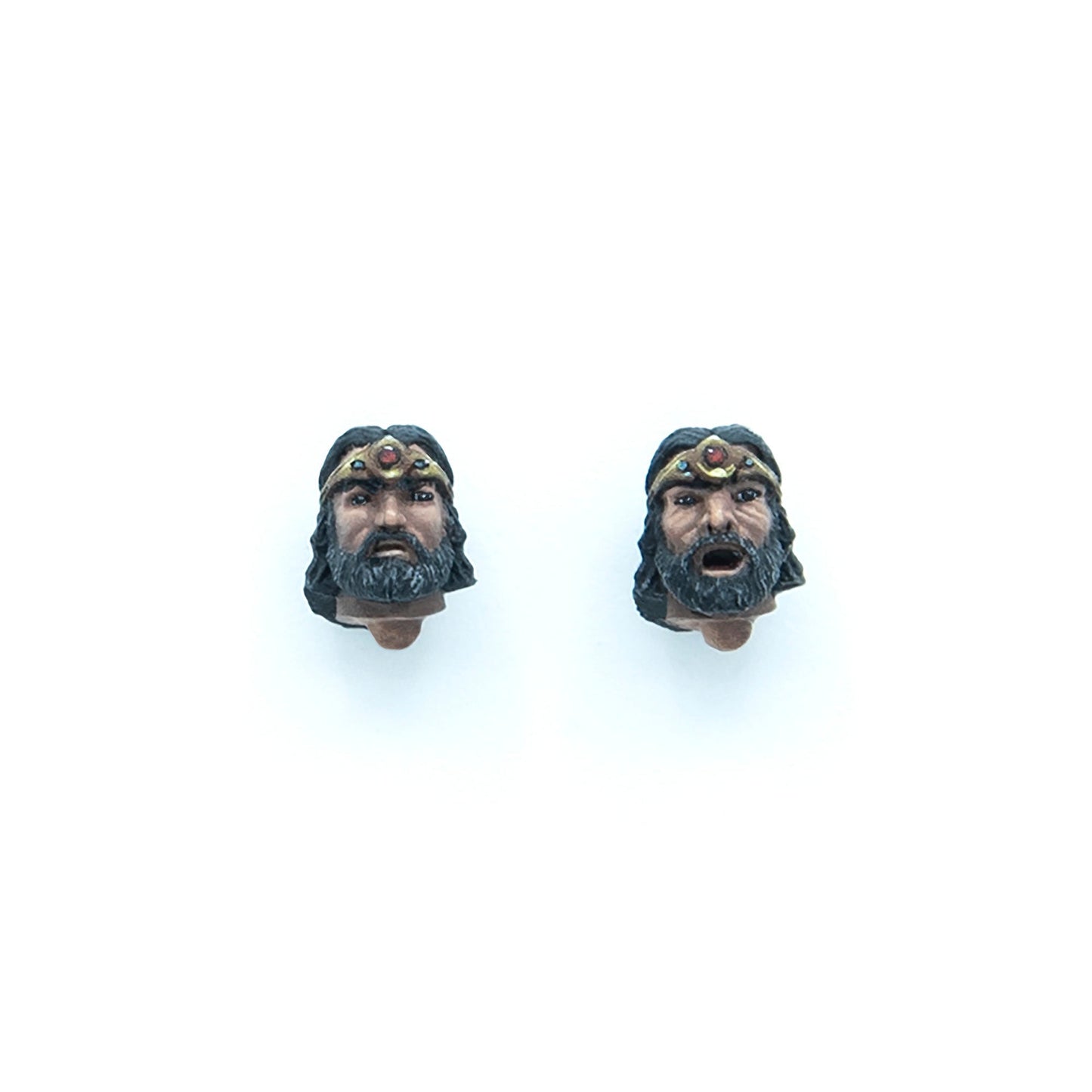 Two interchangeable action figure heads of a bearded man wearing a crown: one neutral, one with an open mouth