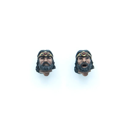 Two interchangeable action figure heads of a bearded man wearing a crown: one neutral, one with an open mouth