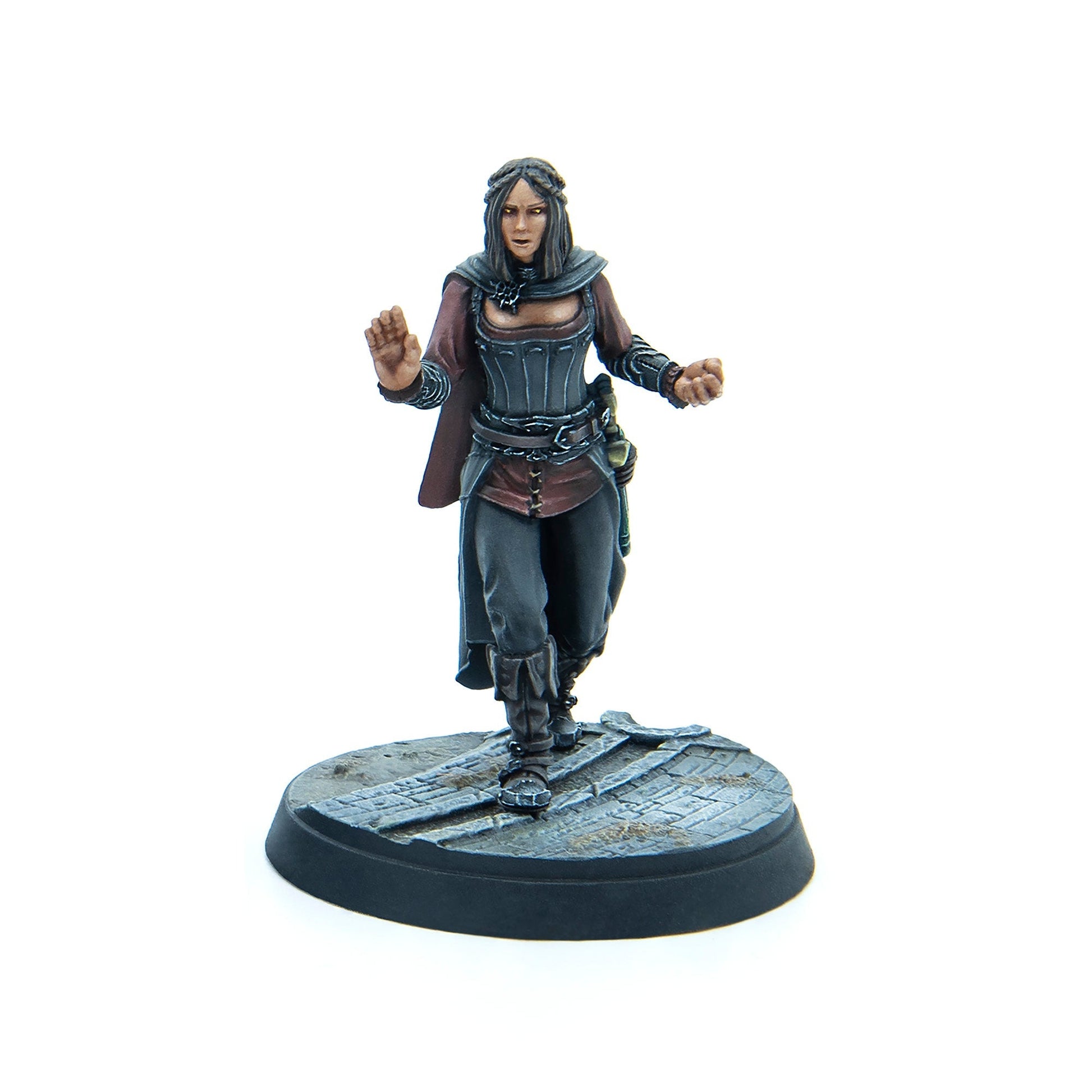 Hand-painted fantasy miniature of a woman in a corset and cape, with glowing eyes, raising hands to cast a spell
