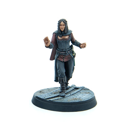 Hand-painted fantasy miniature of a woman in a corset and cape, with glowing eyes, raising hands to cast a spell