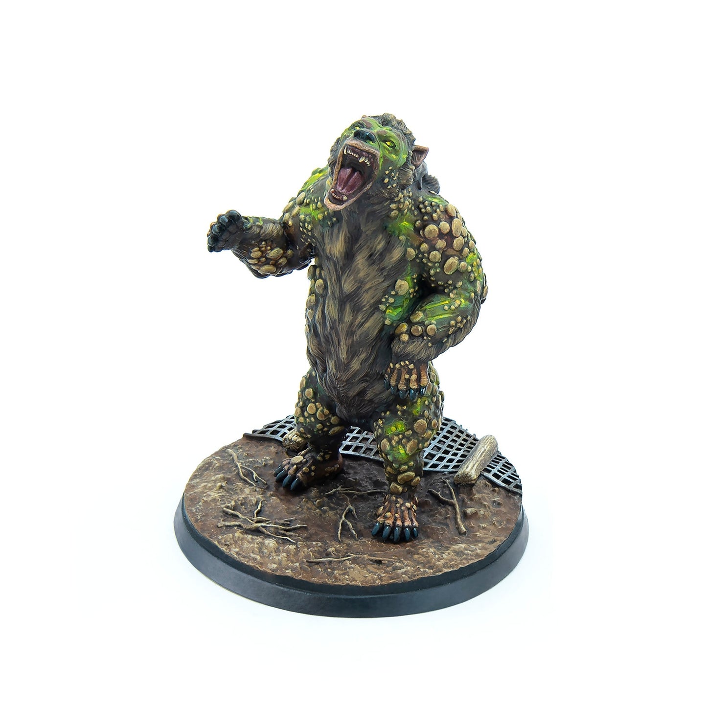 A miniature monstrous creature with brown fur and green, bumpy growths, snarling with an open mouth and extended arm, on a gritty base