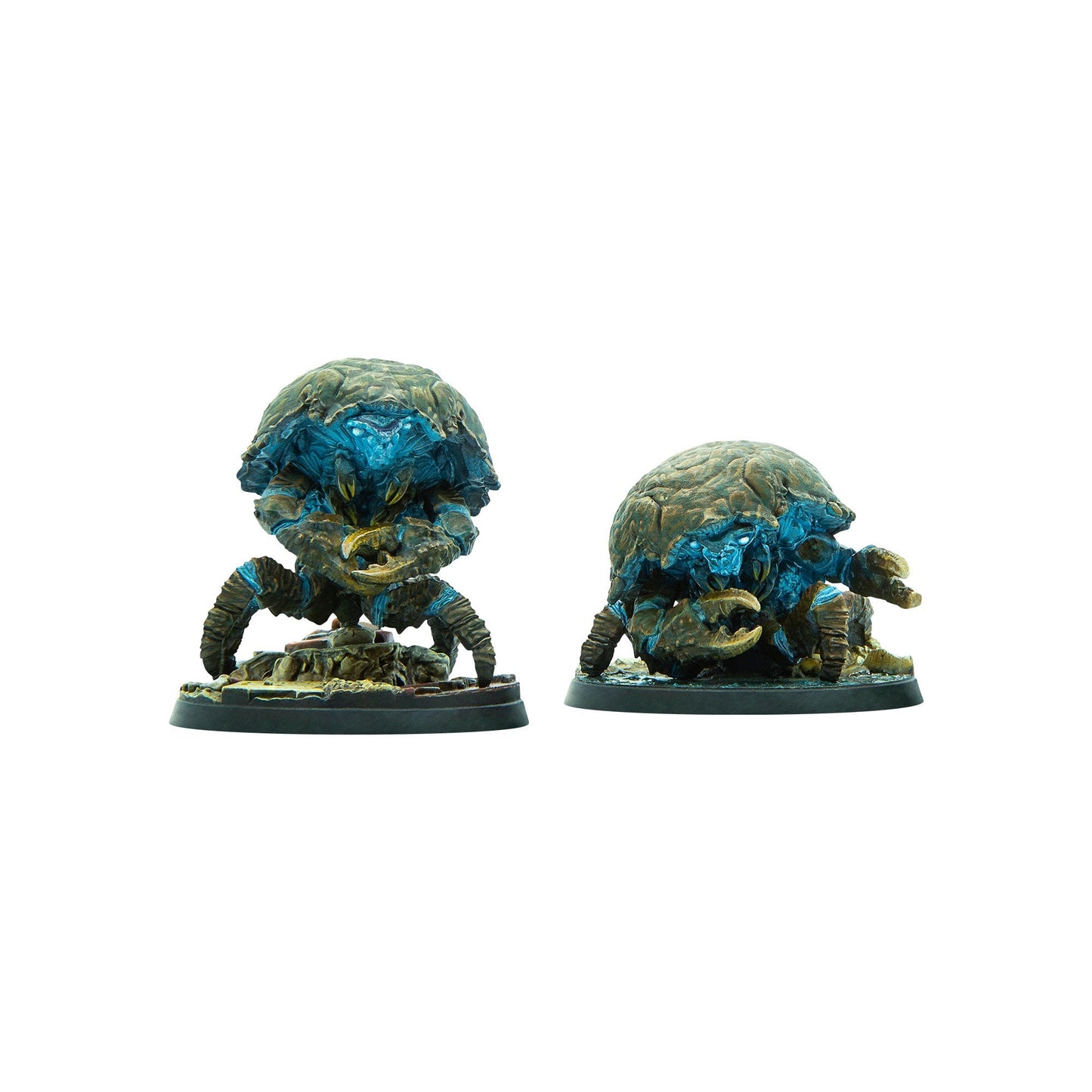Two armored crab-like miniatures with glowing blue faces and large claws stand on rocky bases