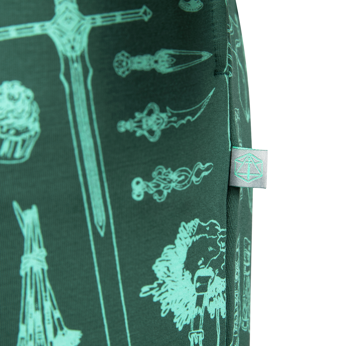 Dark green textile patterned with teal line art of fantasy weapons and objects. A small grey tag with a teal logo is stitched on the right