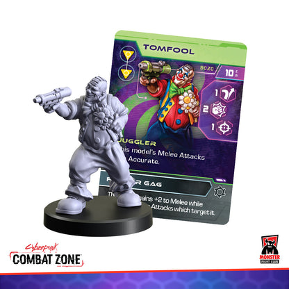 A gray miniature of Tomfool, a clown-like character, pointing a gun, with his game card behind him