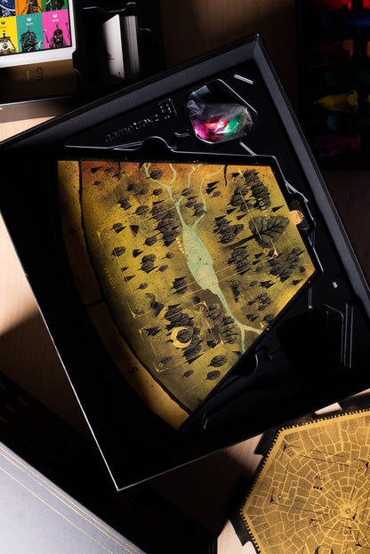 Game box insert with a large, gold and black forest map tile, character cards and tokens