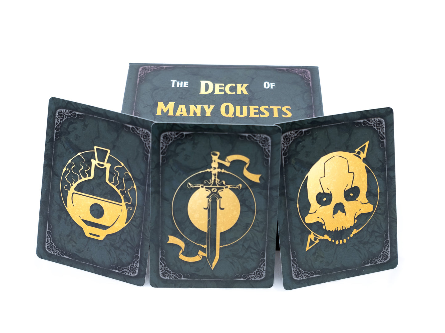 Three fantasy playing cards (potion, sword, skull) fanned out in front of “The Deck of Many Quests” box