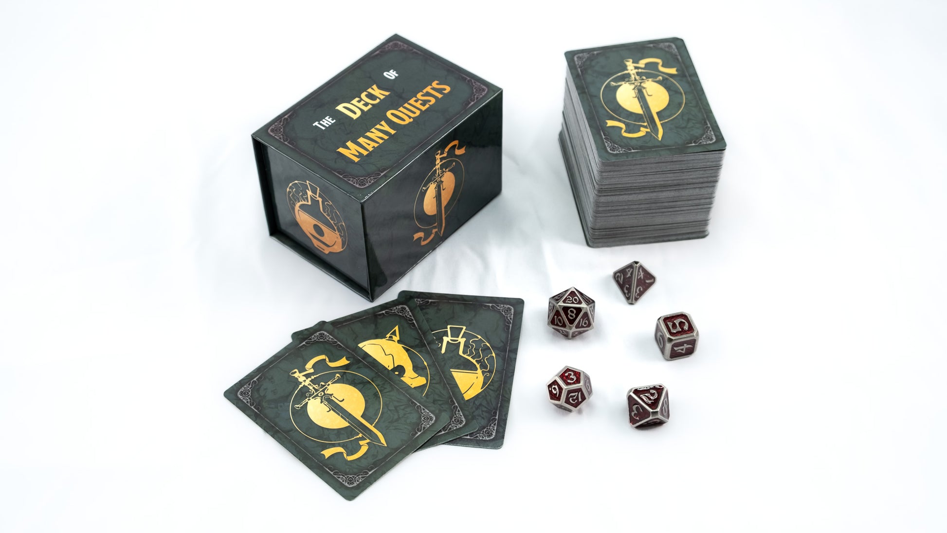 Tabletop game components: "Deck of Many Quests" box, stacked cards, and metal polyhedral dice