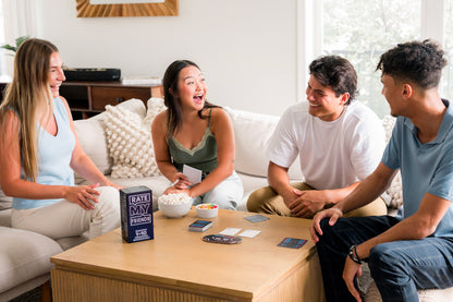 Four friends play the party game Rate My Friends with popcorn and candy on the coffee table