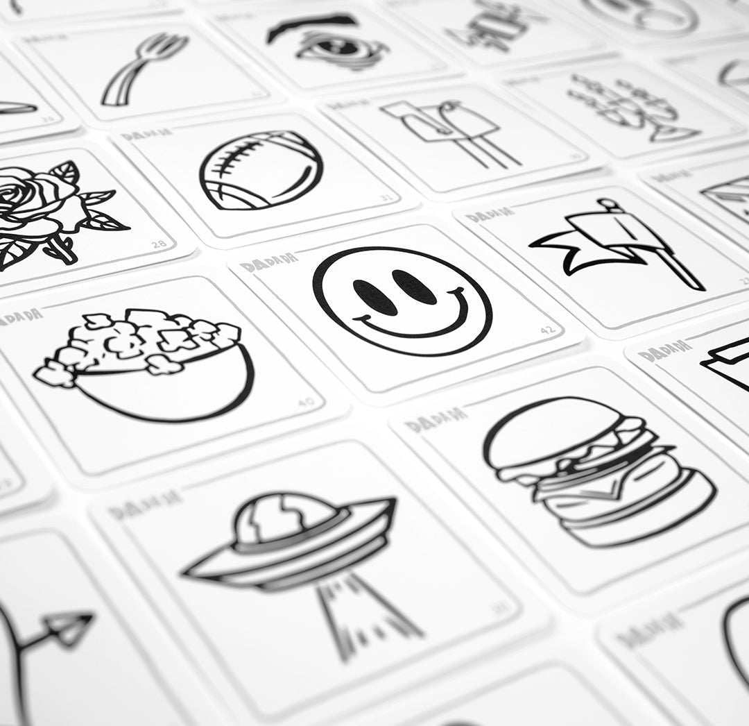 White game cards with black line drawings like a smiley face, burger, and UFO, arranged in a grid