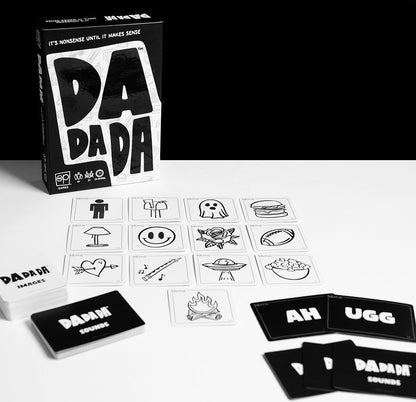 Black and white photo of the 'DaDaDa' card game, with its box, white image cards (ghost, burger), and black sound cards laid out