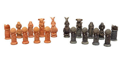 Two sets of intricately carved Australian animal chess pieces, one reddish-brown and one dark grey, arranged in rows