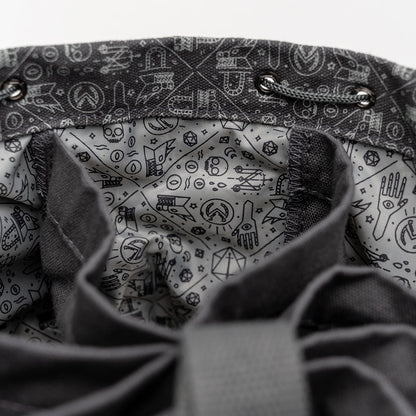 Close-up of an open dark grey drawstring bag's interior, showing a light grey lining with D&D-themed patterns