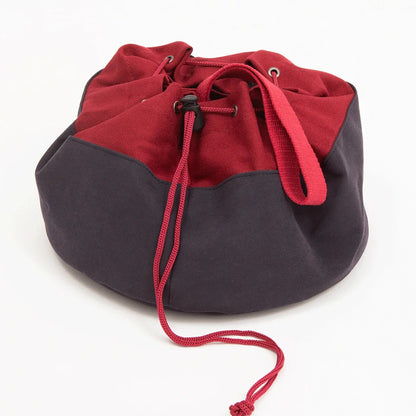 Dark red and charcoal fabric drawstring bag with a red cord, black cord lock, and red loop handle