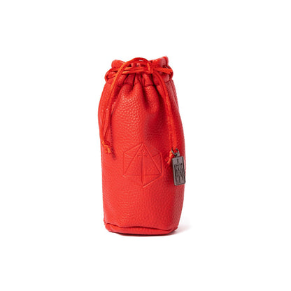 A red textured drawstring dice bag with an embossed sword-in-polygon symbol and a silver charm, on white