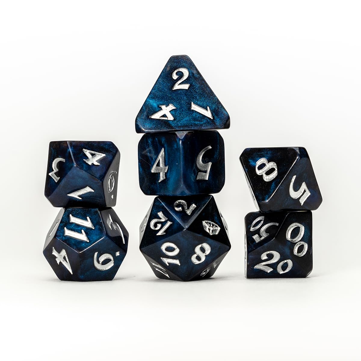 A set of blue and silver marbled polyhedral gaming dice, stacked neatly on a white background