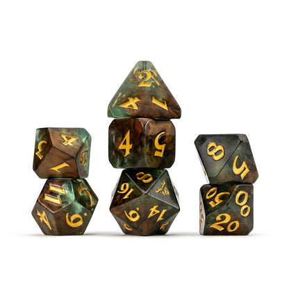 Seven marbled green & bronze polyhedral dice with gold numbers, arranged in three stacks on white