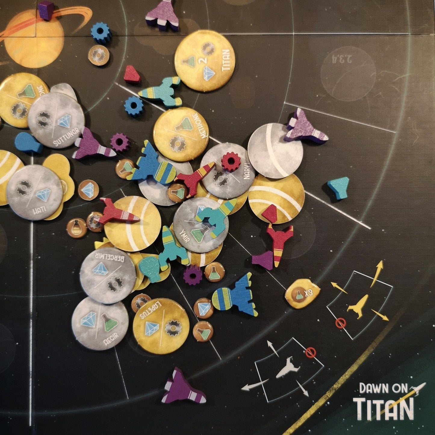 Detailed view of game components from Dawn on Titan including cards, tokens, tiles, and ships arranged on a table