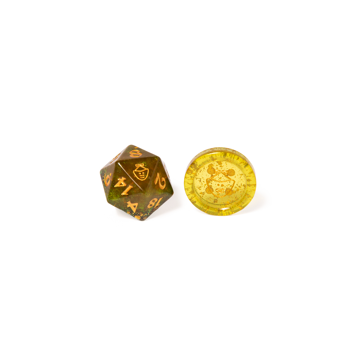 Olive green and gold D20 die and a matching yellow translucent gaming token, both with a stylized symbol