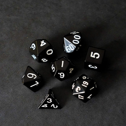 Full black metal polyhedral dice set fanned out on dark background premium RPG tabletop gaming dice