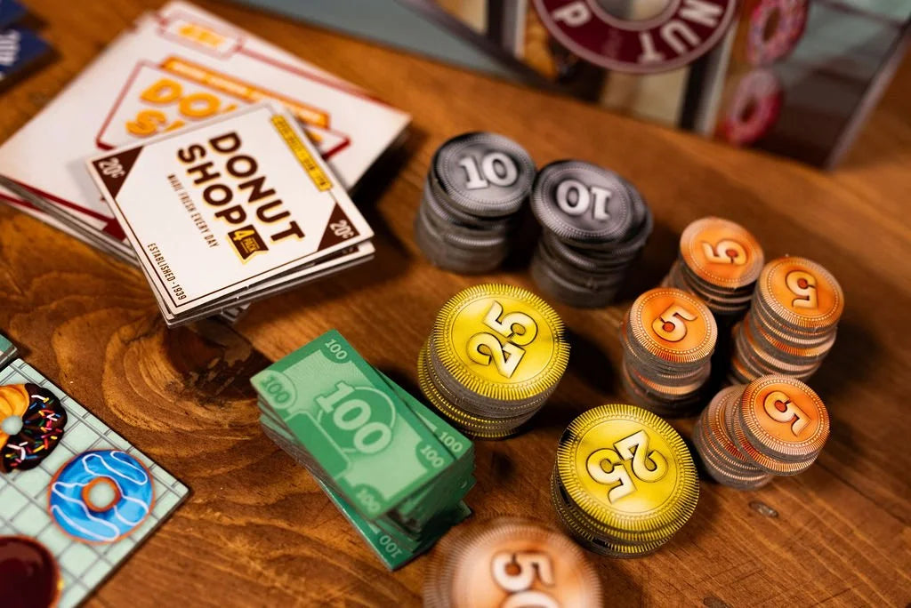 Donut Shop 6-player board game components including game money gold 25-cent coins silver 10-cent coins and orange 5-cent coins