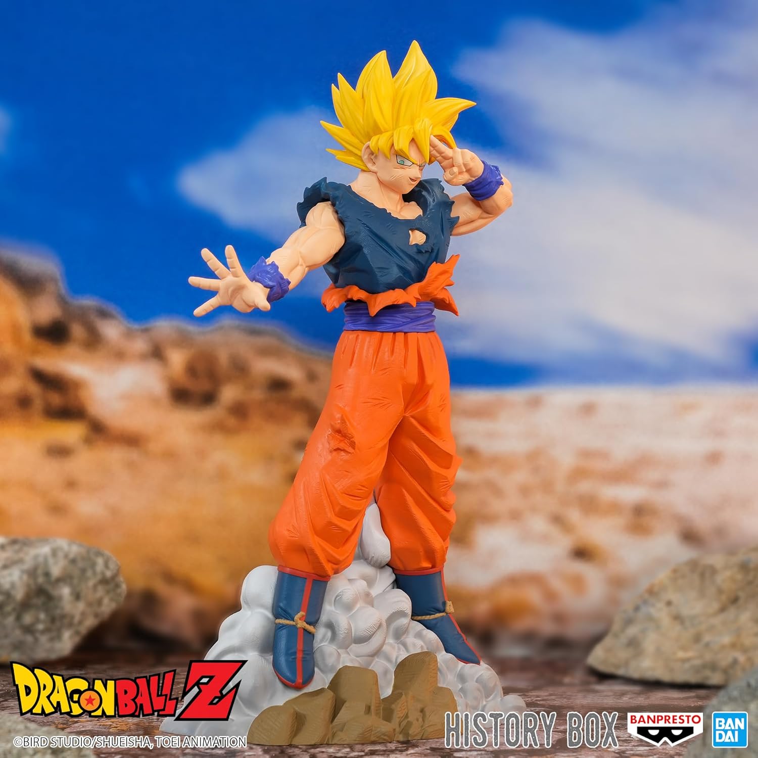 Super Saiyan Goku figure in battle-damaged gi, hand to head in Instant Transmission pose, on a rocky desert landscape