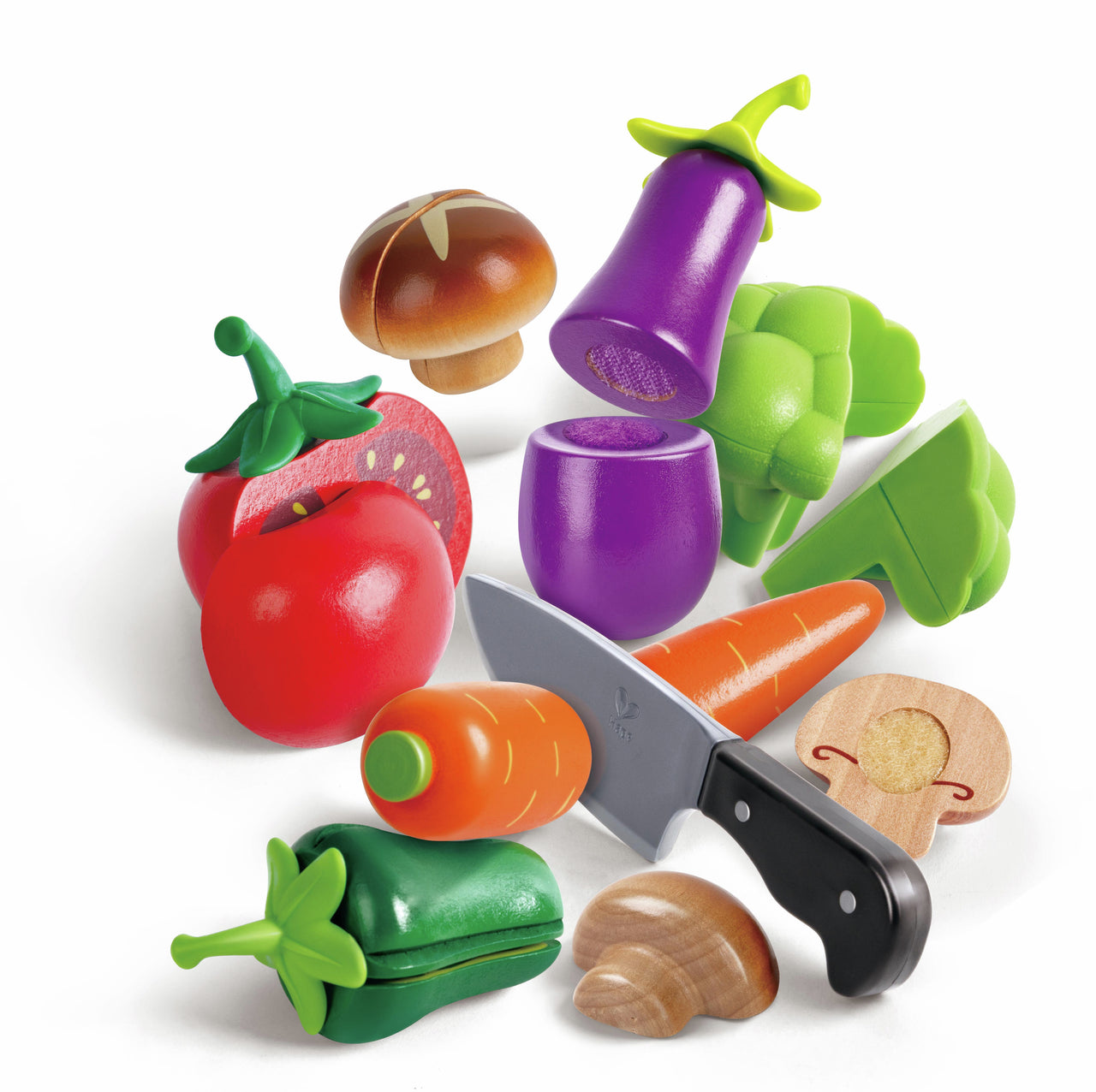 Colorful wooden and plastic play vegetables and a toy knife, including cut tomato, carrot, and mushroom pieces