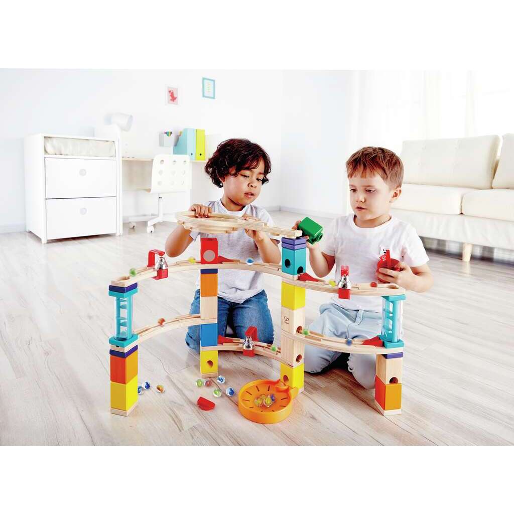 Two boys playing with a large, colorful wooden marble run set