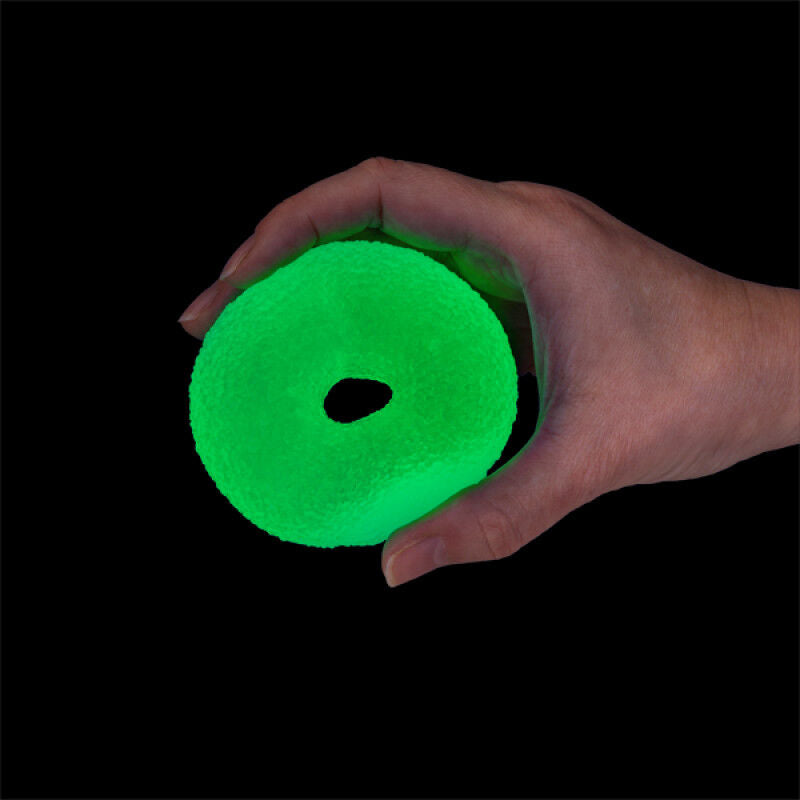 Hand holding a textured, glow-in-the-dark green ring on a black background