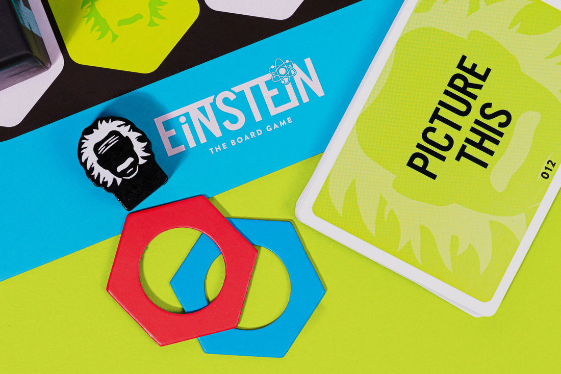Einstein: The Board Game components, including the Einstein token, hexagonal pieces, and a "Picture This" card