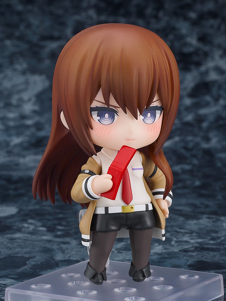 Nendoroid 135 Kurisu Makise figure in tan coat and red tie holding red flip phone